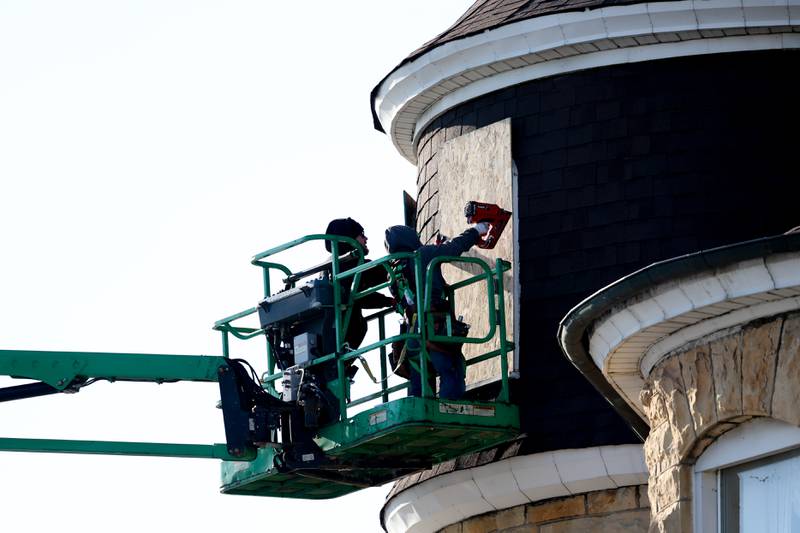 A cleanup and restoration company boards up a window damaged by a fire at the Haley Mansion on Wednesday evening.