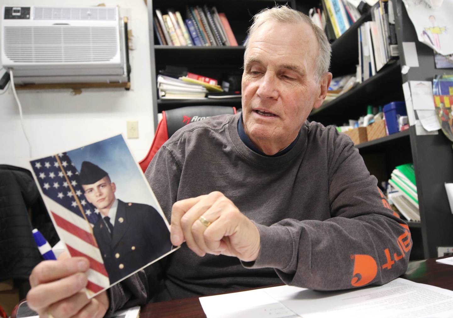 Thomas Inboden, U.S. Army veteran and owner of Inboden’s Gourmet Meat and Specialty Foods in DeKalb, holds a picture of one of his sons who also served as he talks Tuesday Sept. 19, 2023, at his store, about his time in the service and how it prepared him to be a successful business owner and family man.