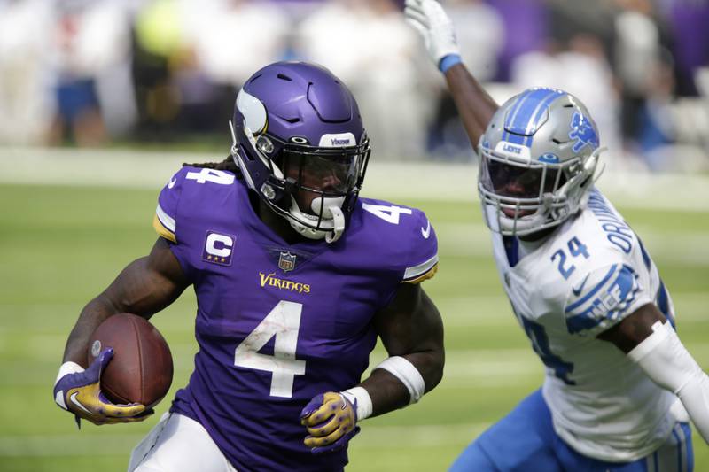 Minnesota Vikings running back Dalvin Coo runs from Detroit Lions cornerback Amani Oruwariye during the first half, Sunday, Sept. 25, 2022, in Minneapolis.