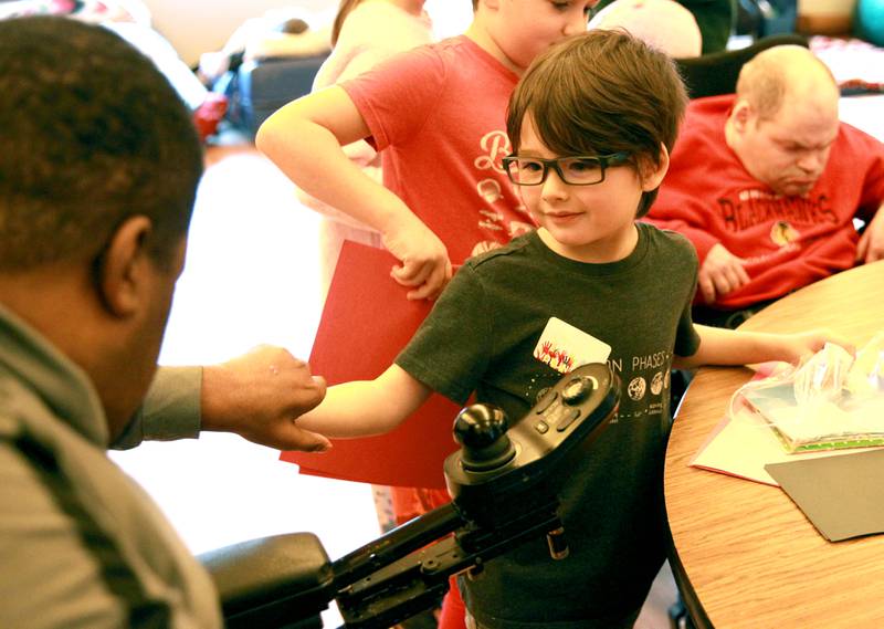 Grace McWayne Elementary School first grader Kiptyn Tabata greets Marklund Hyde Center resident Darren W. as the children created Valentines with the residents on Wednesday, Feb. 7, 2024.