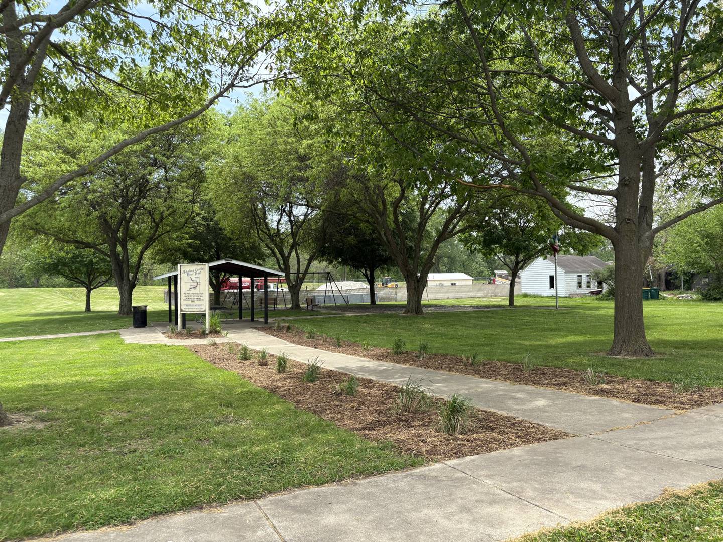 A newly cleared flower bed and trimmed native grasses line the sidewalk leading up to the playground at Merriner Park, part of the city’s effort to improve the look and accessibility ahead of next week’s new playground installation.