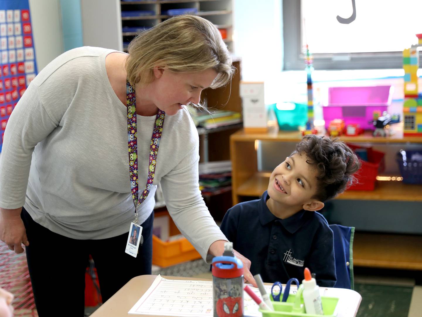 Lori McNaught helps one of her kindergartners at St. Matthew Parish School in Glendale Heights.