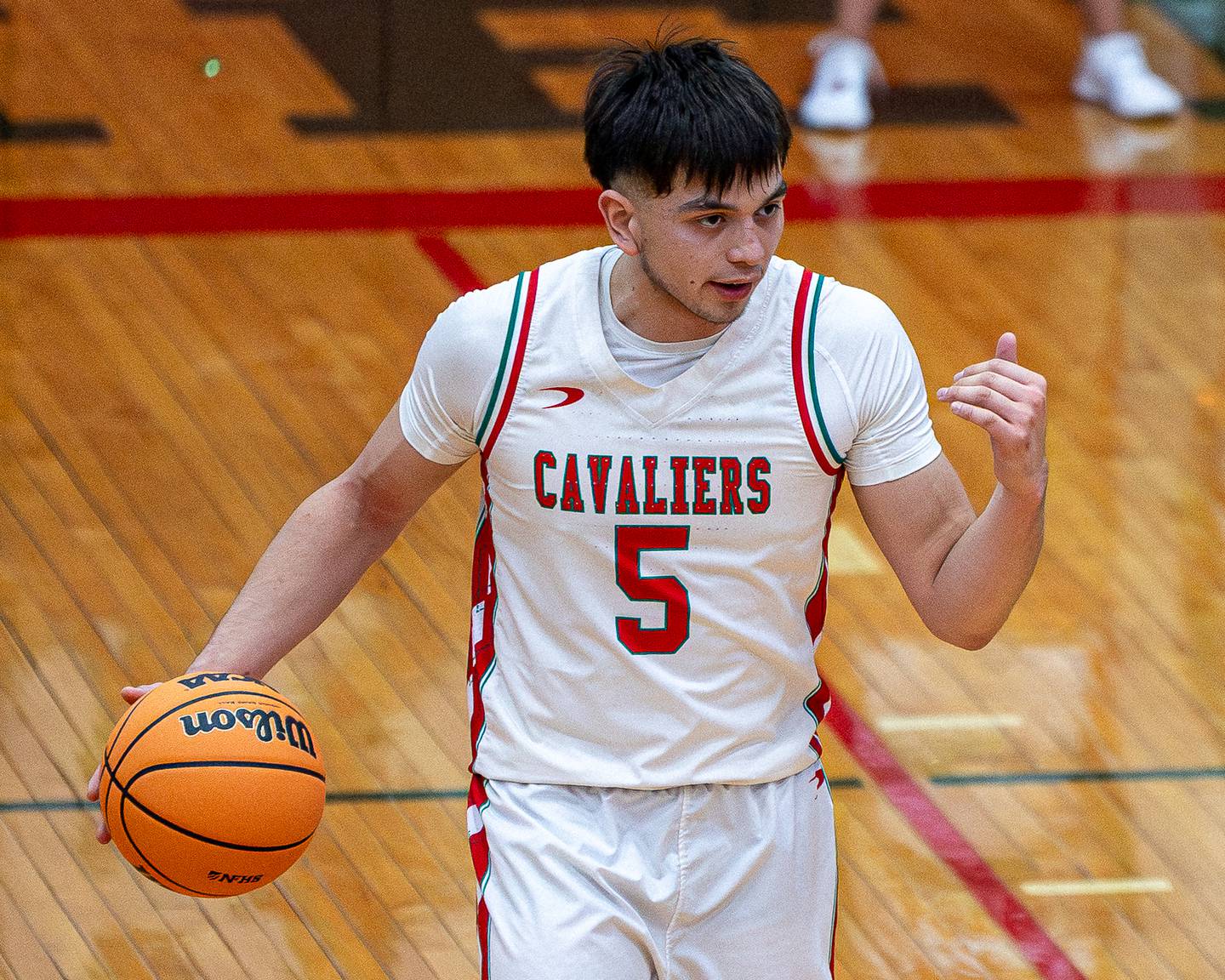 Erick Sotelo (5) of LaSalle-Peru motions for teammates help whilst dribbling ball down court in game against Kaneland on Friday, Feb. 20, 2026 in Sellett Gymnasium at L-P High School.