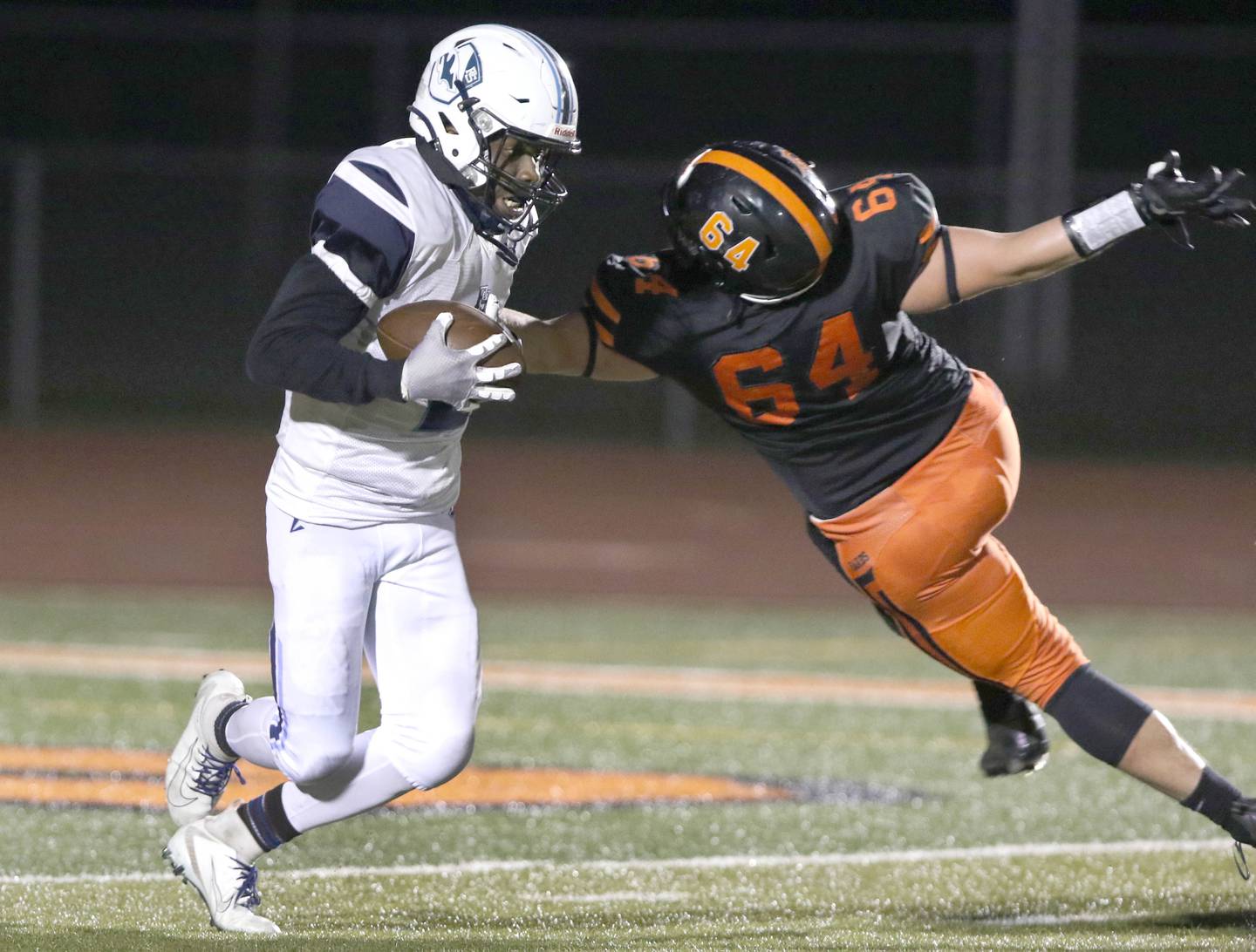 Plainfield South running back Johnny Bailey gets by the outstretched arms of DeKalb's Gavin Engh during their game Friday, Sept. 3, 2021 at DeKalb High School.