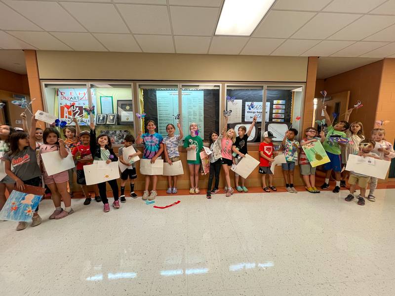 Students hold their artwork at a previous Plainfield East High School’s Summer Art Studio. Registration is now open for the 2024 Summer Art Studio.