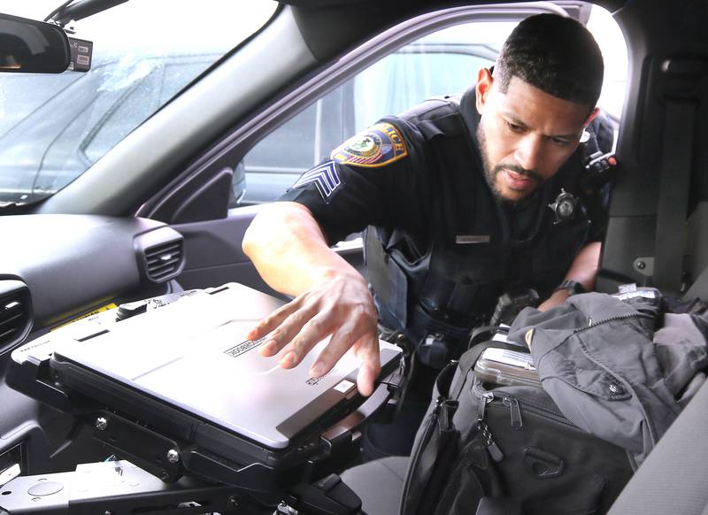 DeKalb Police Sgt. Raynaldo Hernandez opens the computer in his squad car as he prepares to start his shift Thursday, April 11, 2024, behind the DeKalb Police Department.