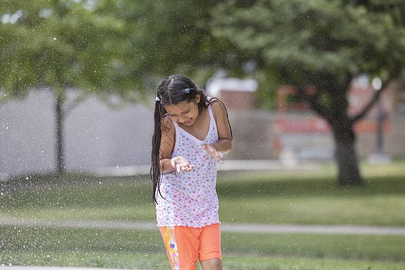 Elizabeth James, 7, shies away from a spray of water at Sterling’s new Grandon Civic Center splash pad Wednesday, May 31, 2023.