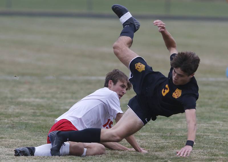 Richmond-Burton's Alex Munoz flies to the ground after being slide tackled by Marian Central's Jacob Schug during the IHSA Class 1A Marian Central Regional Boys Soccer Final match on Tuesday, Oct. 22, 2024, at Marian Central High School in Woodstock.