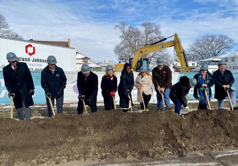 DeKalb area officials including elected leaders, staff and supporters of Safe Passage Inc., pose for a group photo on Friday, Dec. 5, 2025, at the agency's ceremonial groundbreaking to mark the start of construction on a new domestic violence survivor shelter at 217 Franklin St., in DeKalb.