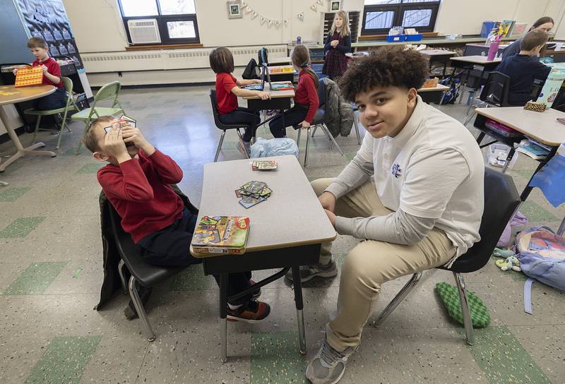 Dixon St. Mary’s second grader Daniel reacts to getting hit with a Draw 4 card by Newman freshman Travonn Walker on Wednesday, Jan. 29, 2025. NHS students visited the school to play games with the kids in celebration of Catholic Schools Week.