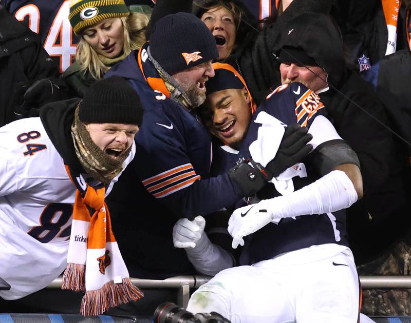 Chicago Bears safety Jaquan Brisker (right) jumps into the stands to celebrate after their 22-16 overtime win against the Green Bay Packers Saturday, December 20, 2025, at Soldier Field in Chicago.
