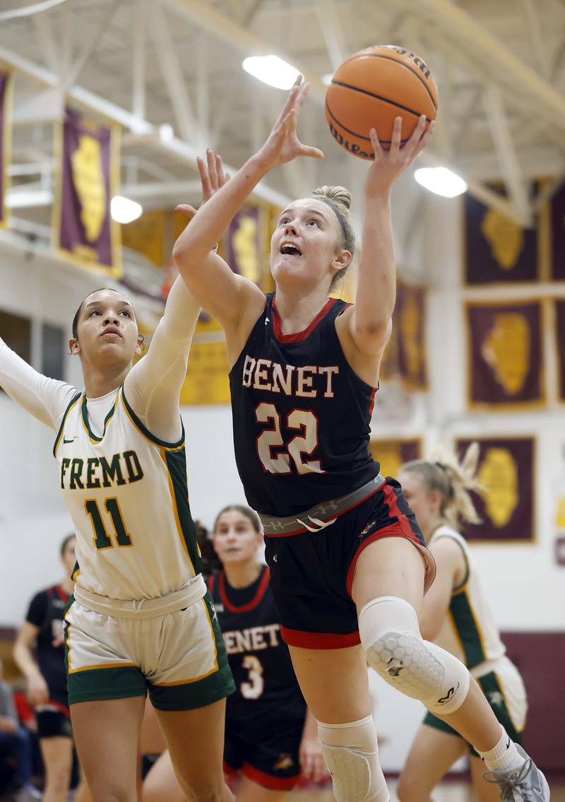 Benet Academy's Bridget Rifenburg (22) attacks the basket past Fremd’s Coco Urlacher (11) during the Montini girls basketball Christmas tournament Saturday, Dec. 28, 2024 in Lombard.