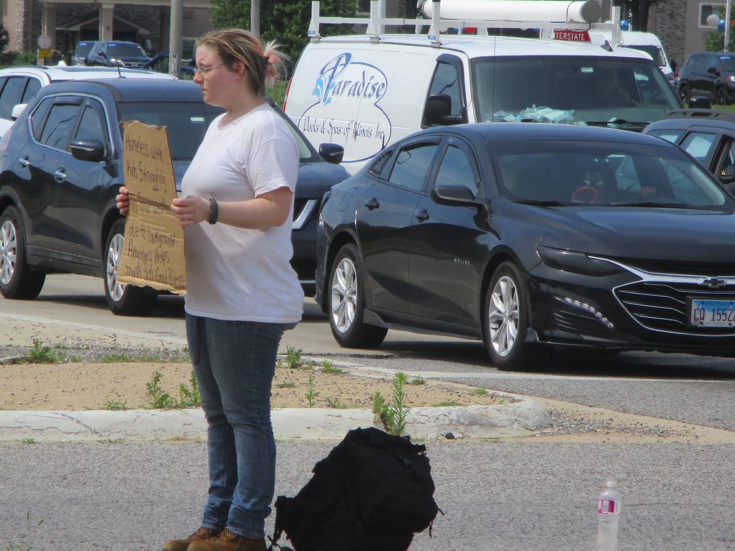 Ashley Hill stands on a raised median on Mall Loop Drive at the Route 30 intersection seeking money on July 2, 2022.