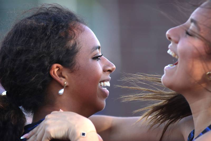Woodstock’s Amina Idris, left, is all smiles while being mobbed by teammates after the 100-meter hurdles in IHSA Class 2A Girls Sectional Track action at Genoa-Kingston School in Genoa on Friday, May 16, 2025.