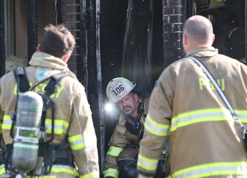 Oglesby Assistant Fire Chief Steve Maltas crawls out of the front door during a fire at a duplex home in the 200 block of Sunset Boulevard on Tuesday, Oct. 24, 2023 in Oglesby.