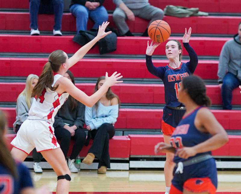Oswego’s Emily Mengerink (12) shoots a three pointer against Naperville Central during a basketball game at Naperville Central High School on Friday, Nov 17, 2023.
