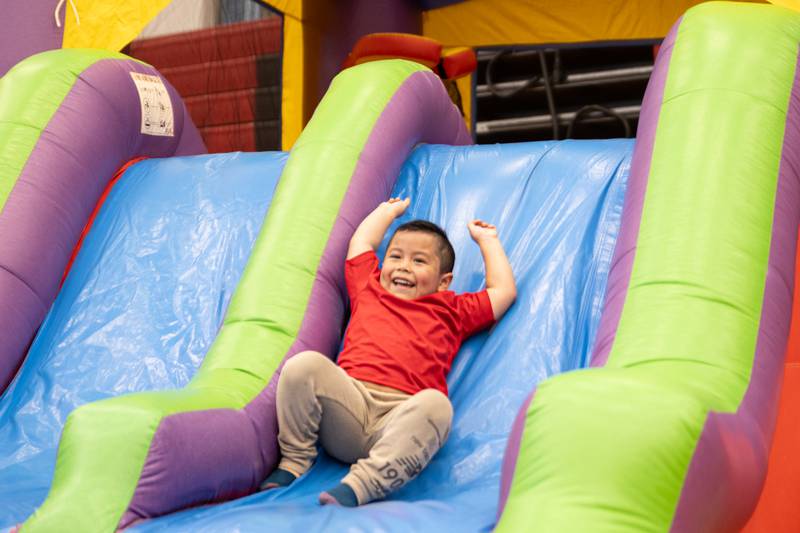 Child slides down “bouncy house” at the annual Easter Egg hunt on Saturday, April 12, 2025 at Hall High School in Spring Valley.