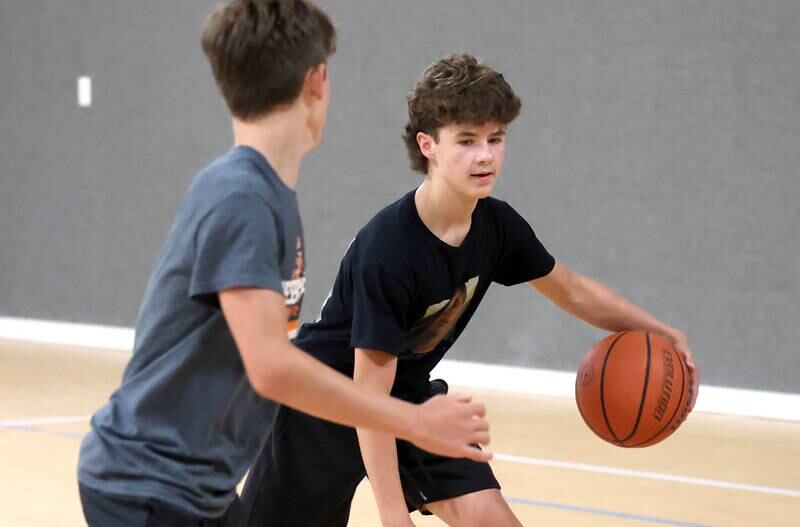 Caleb Krueger, (left) 13, guards his brother Cole, 15, Wednesday, Aug. 28, 2024, as they play basketball at their house in Genoa. The pair recently earned Guinness World Record record for the most basketball passes in a minute for a pair under 16 and are planning an attempt at breaking the world record for the most three pointers in a minute by a duo.
