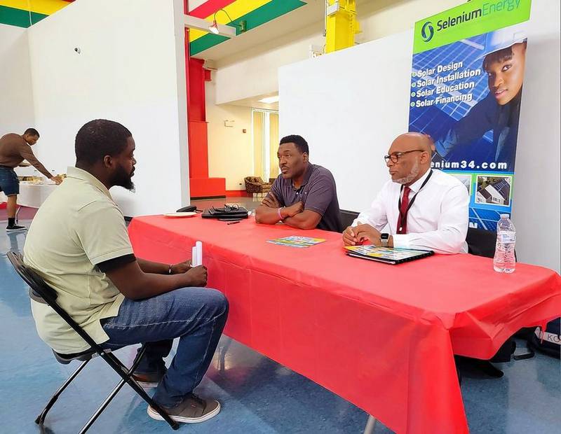 Selenium Energy president and CEO Troyce Polk, middle, at an employment fair over the summer. Polk is in the process of hiring workers ahead of a residential solar project his company will be working on in the coming year.