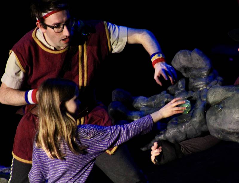 An audience member tries to pull a diamond from the paw of a stone troll during a performance of "Dragons and Mythical Beasts" on Saturday, Feb. 11, 2023, at Dixon Theatre.