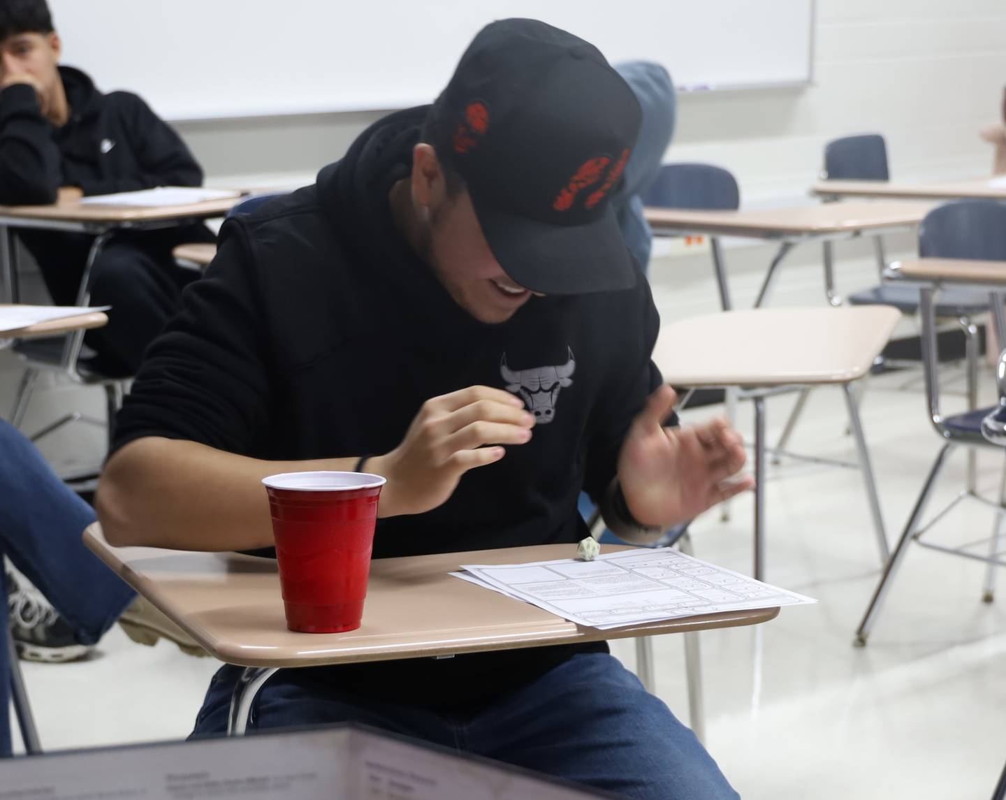One of the Transition English students at McHenry High School's Upper Campus rolls the dice to see what his character will do next on Thursday, Jan. 22, 2026. The class is using the role playing game as an immersive way to learn English.