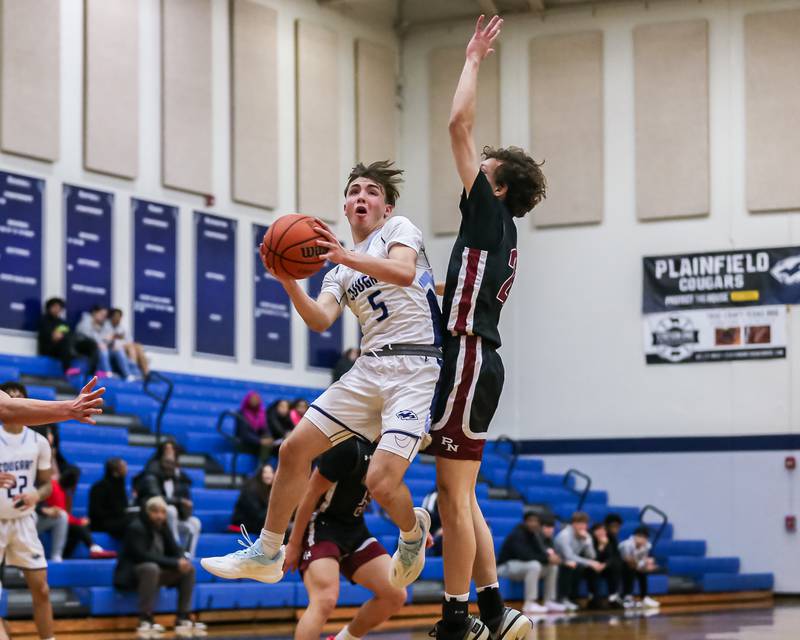 Plainfield South's Devin Tyda (5) is met a the rim by Plainfield North's Tyler Lamb (21) during basketball game between Plainfield North at Plainfield South. Jan 5, 2024.