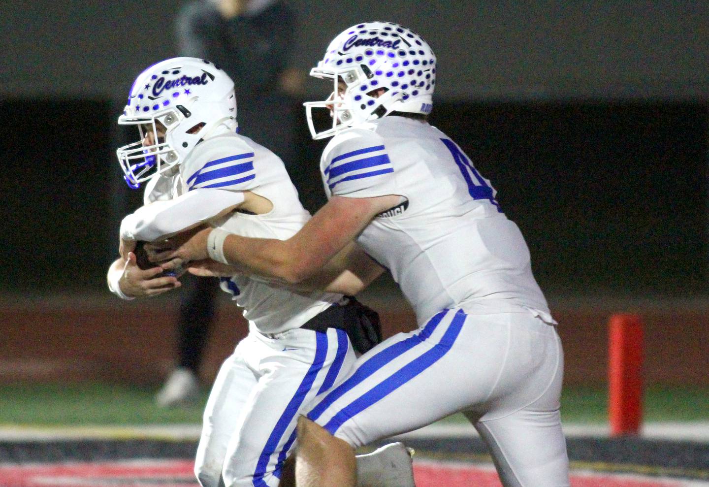 Burlington Central’s Zane Pollack, left, takes a handoff from  Jackson Alcorn in varsity football at Huntley High School in Huntley on Friday, Oct. 25, 2024.