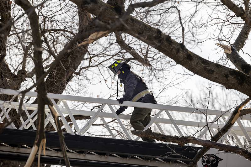 A firefighter makes his way to the the top of a ladder during the search for a house fire victim Monday, Jan. 20, 2025