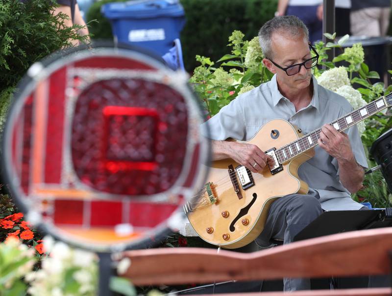John Papadolias plays the guitar in the Plandscape area Saturday, July 26, 2025, during the Geneva Arts Fair on Third Street in Geneva.