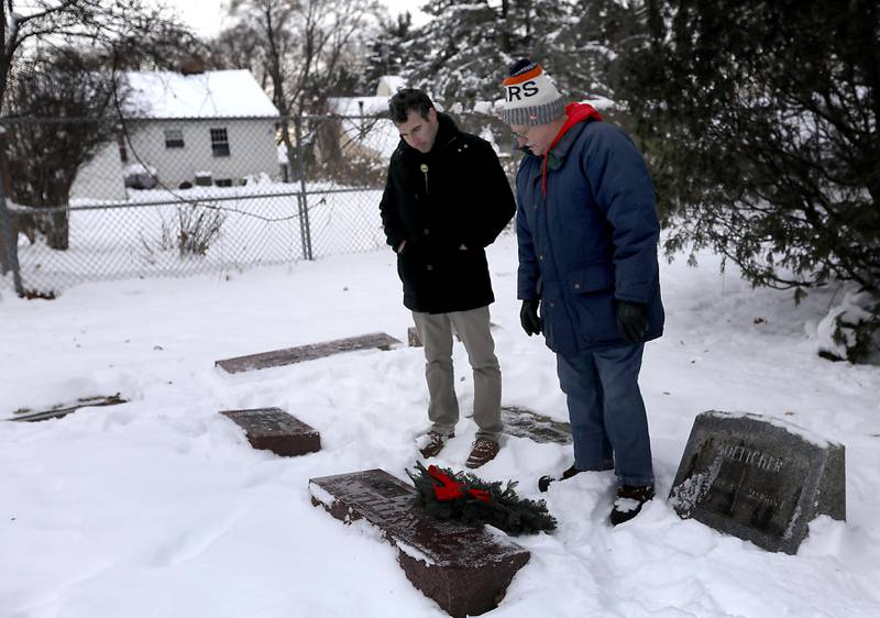 Austin May and Larry Cannon pay their respects after laying a wreath at a veteran’s gravesite during McHenry's Wreath Laying Ceremony in honor of fallen veterans on Friday, Dec. 5, 2025,, at St. Mary's Catholic Cemetery in McHenry. The event was hosted by McHenry American Legion Post 491 and Team Home Depot.