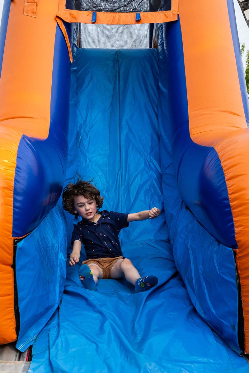 Lockport resident Will Jay goes down an inflatable slide before the concert kicks-off in Lockport's Central Square on June 2, 2025.