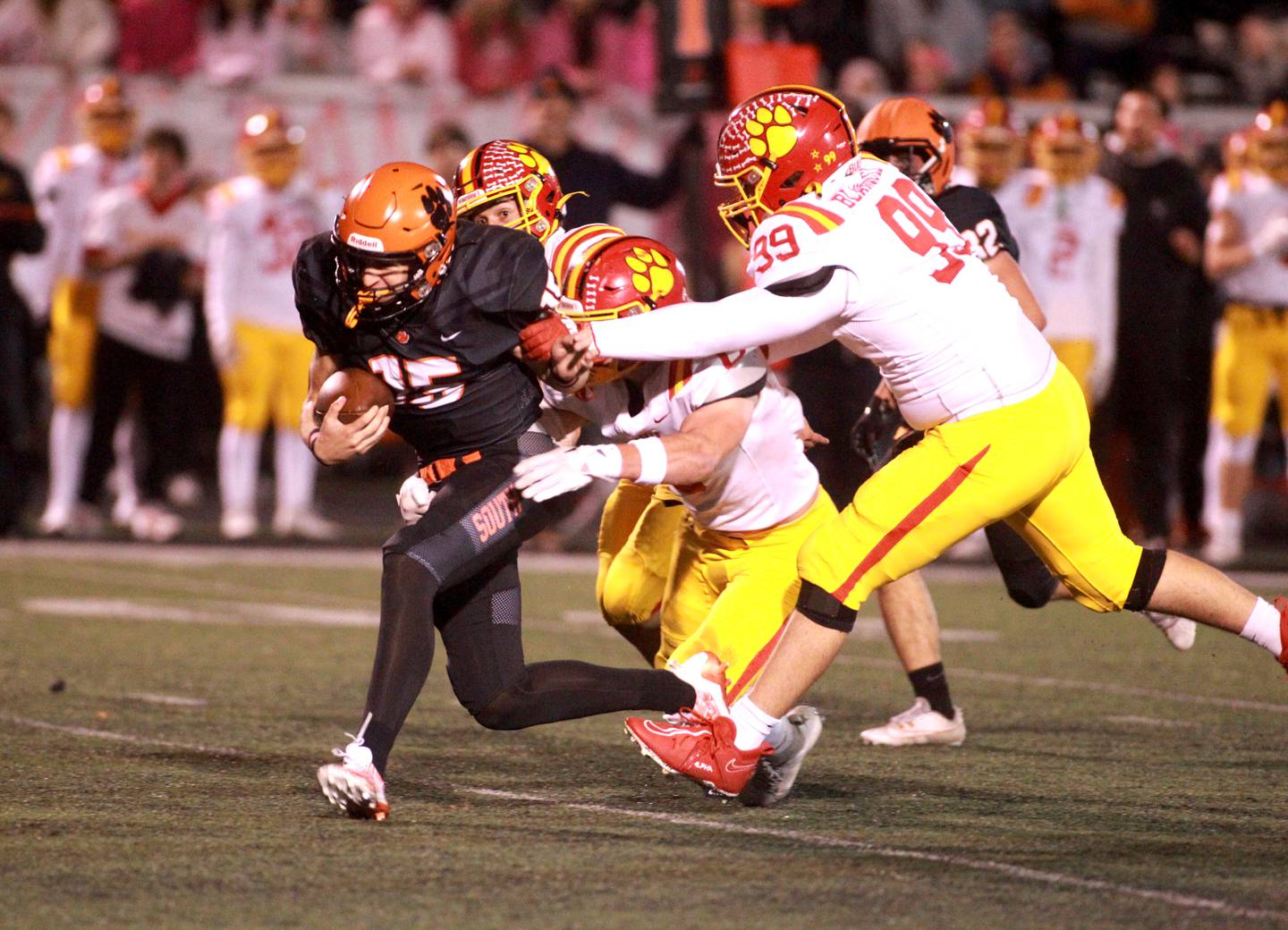 Wheaton Warrenville South quarterback Luca Carbonaro is chased by a trio of Batavia defensemen during a game in Wheaton on Friday, Oct. 13, 2023.