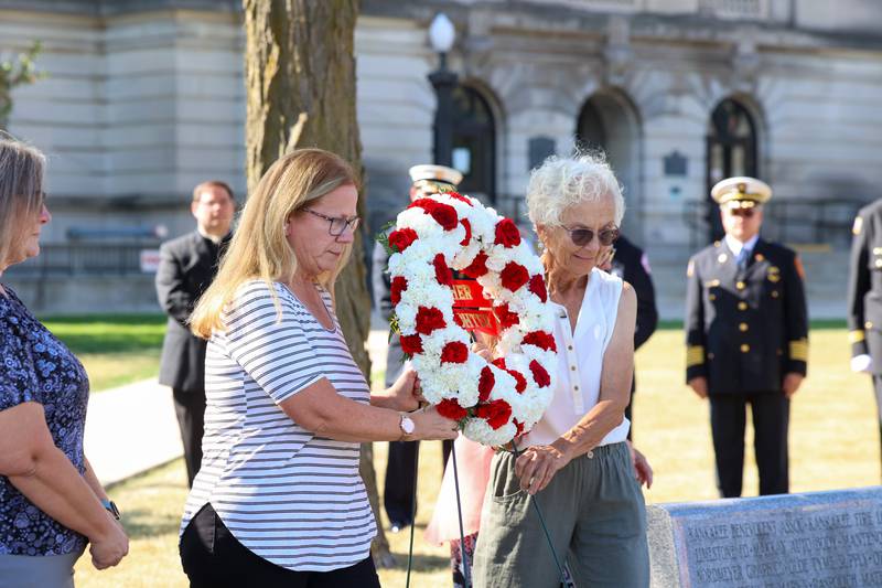 Denise Spaulding, left, of Bourbonnais, wife of fallen Bourbonnais Fire Department firefighter Bruce Spaulding, and Linda Taylor-Gerretse, former wife of fallen  Otto Township firefighter Michael Taylor, help place the wreath during the 44th Kankakee County Fallen Firefighter Memorial Service on Friday, Oct. 3, 2025.