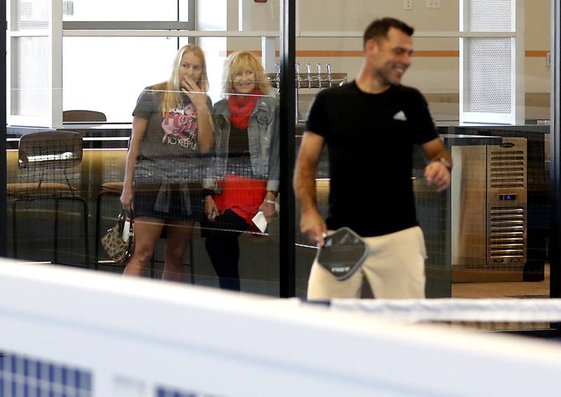 Tammy Rucinski and Karen Run watch a pickle ball game during a grand opening ceremony for the Pickle Haus in Algonquin, on Friday, Nov. 10, 2023. The Pickle Haus offers indoor pickle ball courts, food and drinks. I like this image because it reminds me of innocence of youth.