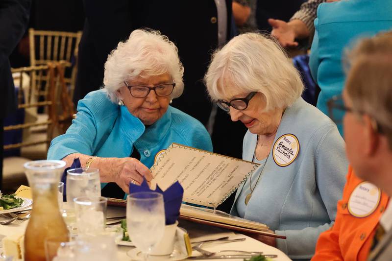 Jeanette D’Arcy, left, and Amanda Nichols, of the Women of Rotary, look over a scrapbook at a luncheon to celebrate the 110th anniversary of the Rotary Club at Jacob Henry Mansion on Tuesday, Aug. 1 in Joliet.
