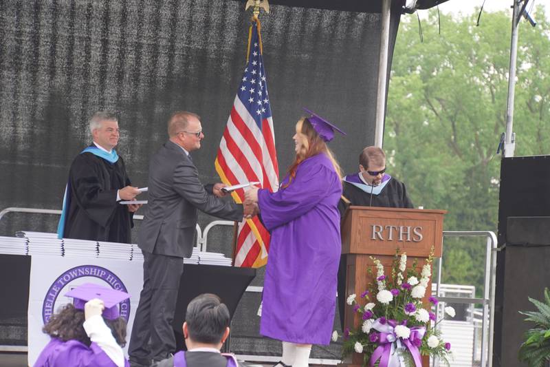 Rochelle Township High School Board President Jeff Tilton presents a student with a diploma at the school's graduation ceremony on Saturday, May 23, 2026.