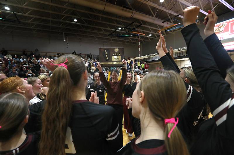 Prairie Ridge Head Coach Leah Groat raises the trophy after Prairie Ridge defeats Carmel in the IHSA Class 3A Carmel Sectional championship volleyball match on Thursday, Nov. 6, 2025, at Carmel High School, in Mundelein.