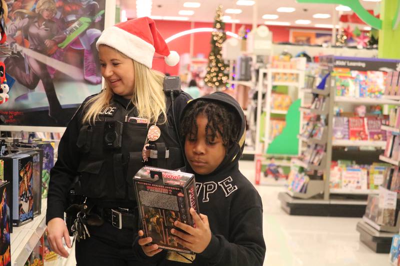 Officer Allie Remner (left) shops with DeKalb resident Tayden Brown, 9, (right) as part of the "Heroes and Helpers" program put on by DeKalb police Sunday, Dec. 4, 2022.