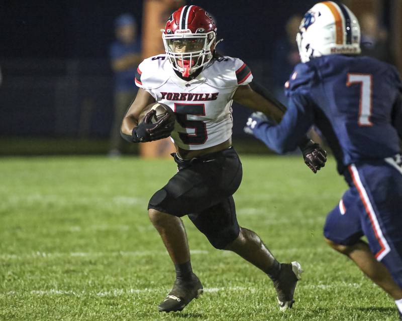 Yorkville's T.J. Harland (5) runs away from Oswego's Dontrell Young (7) during football game between Yorkville at Oswego Friday, Sept 26, 2025 in Oswego.