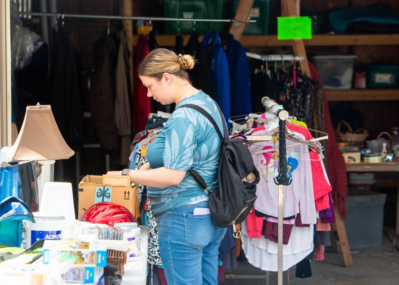 Jillian Rollins of Westmont looks through picture frames at a Westmont home during the town’s weekend garage sales, Sunday, August 4, 2024.