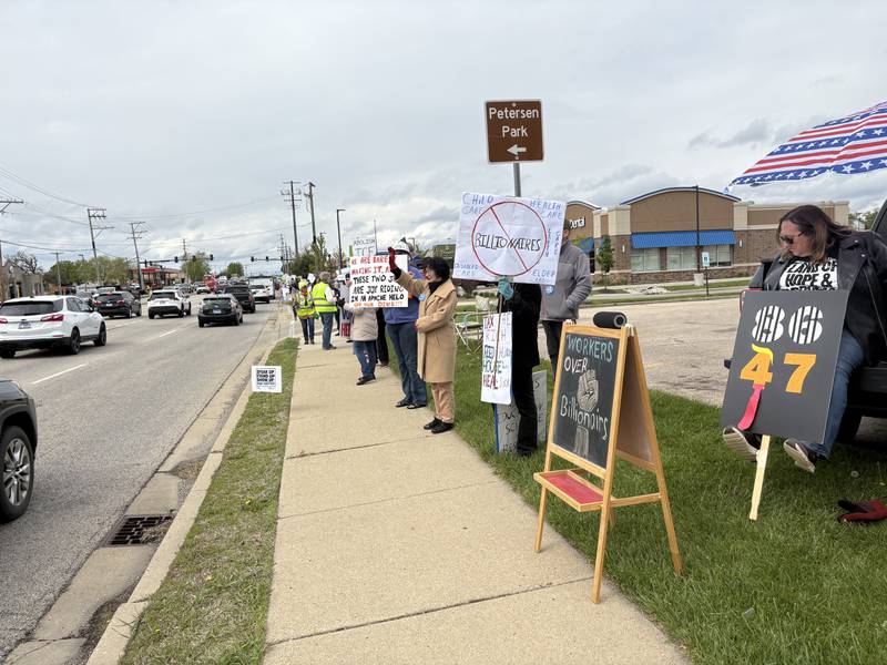 Protestors hold up signs during a May 1 protest in McHenry Friday May 1, 2026.