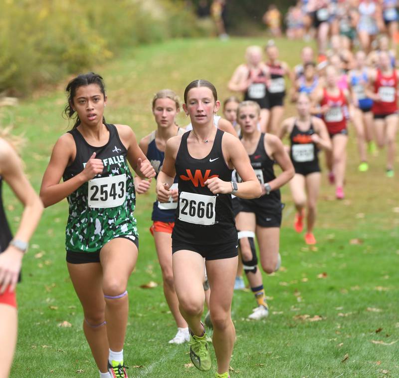 Rock Falls' Brenna Burlack (left) runs at the Amboy Columbus Day Cross Country Invitational held at Shady Oaks Country Club near Amboy on Monday, Oct. 13, 2025. She finished 21st.