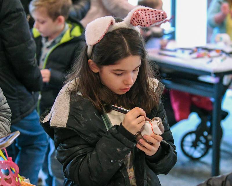 Olivia Kometz, 9, of Naperville paints a puppy bank during the craft portion of the Easter Egg Hunt event held at Cantigny Park on Sunday March 24, 2024.