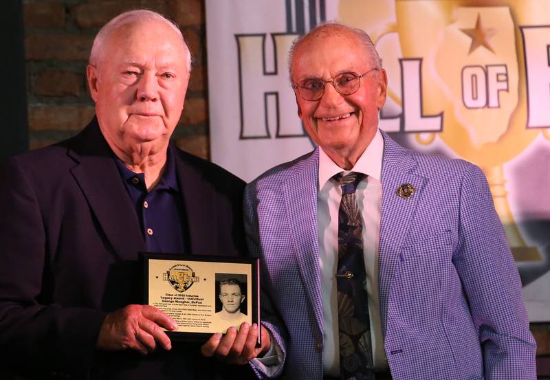 Tom Dobrich, accepts the Legacy Individual Award of friend and DePue native George Meagher, with posing with emcee Lanny Slevin during the 2025 Shaw Media Illinois Valley Sports Hall of Fame at the Auditorium Ballroom in La Salle.