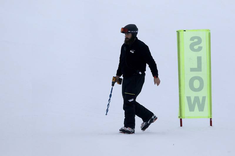 A employee of Wilmot Mountain Ski Resort  walks back to the resort after putting up a sign at the end of a ski run on Thursday, Jan. 16, 2025, in Wilmot, Wisconsin.