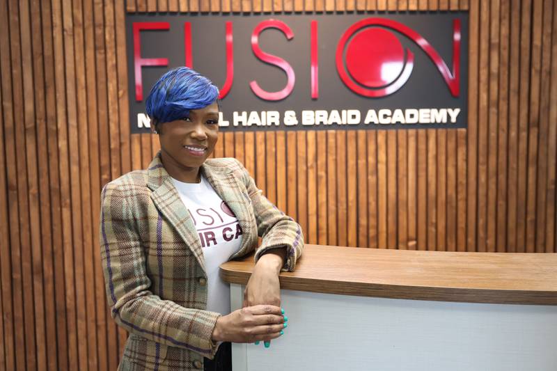 LeAnn Drake, owner of Fusion Natural Hair and Braid Academy, poses for a photo at her academy in Joliet on Wednesday, March 1st 2023.