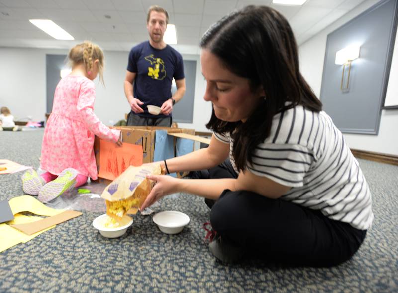 Jill Folds of Lagrange Park pours popcorn into a bowl prior to the movie starting during the Drive In Movie event held at the LaGrange Park District Friday, Feb 23, 2024.