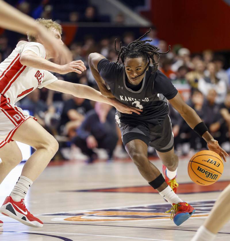 Kaneland's Marshawn Cocroft (3) scoots around Deerfield's Tommy Donahue (4) on his way to the hoop during the IHSA Class 3A boys basketball state semifinal Friday, March 13, 2026 at the State Farm Center in Champaign.