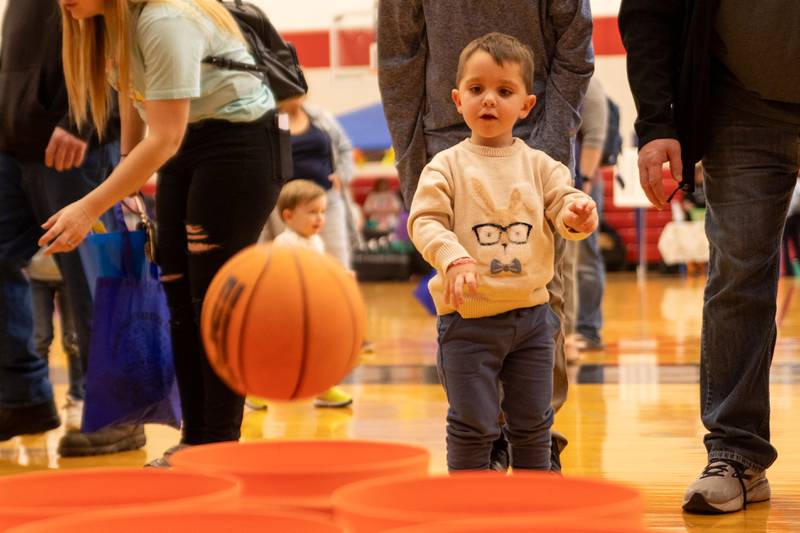 MJ Rebholz throws basketball into bucket at the annual Easter Egg hunt on Saturday, April 12, 2025 at Hall High School in Spring Valley.