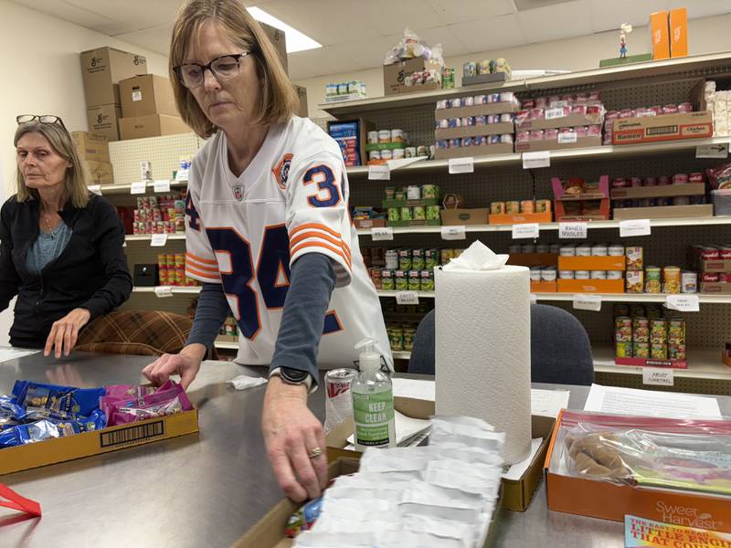 Woodstock Food Pantry volunteer Mary Pletch grabs a packet of hot chocolate Oct. 31, 2025.